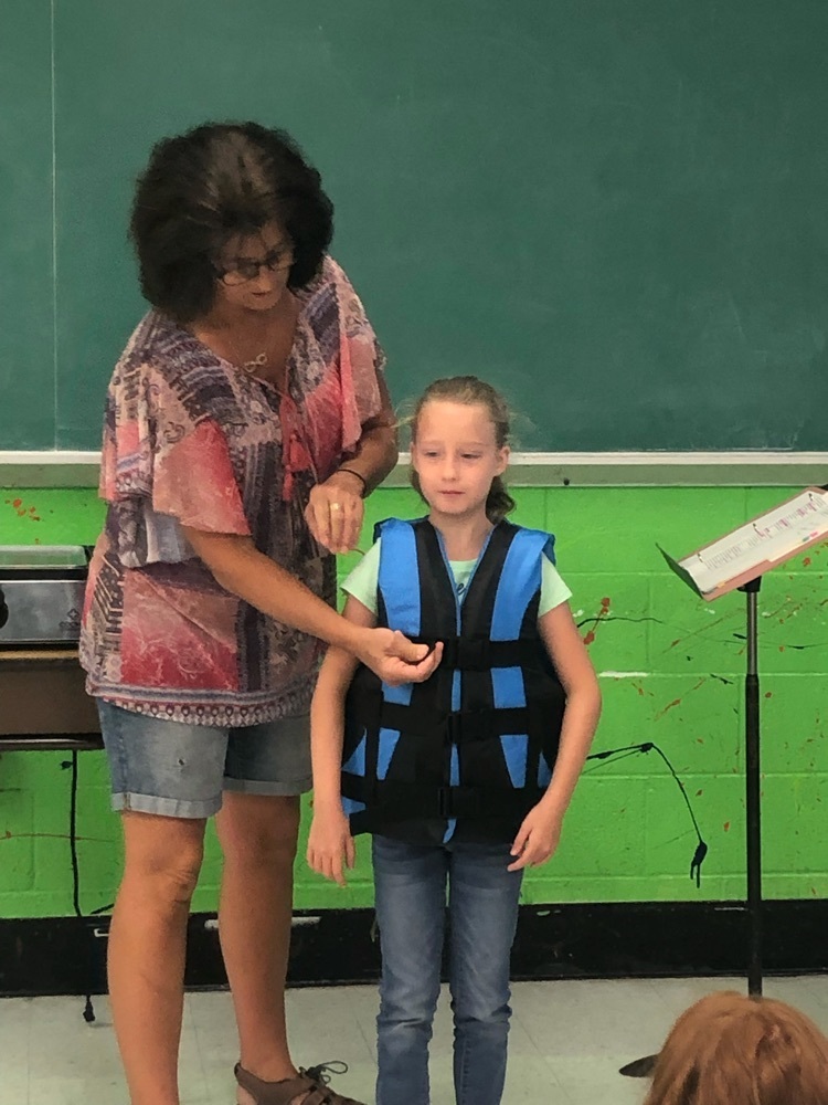 Mrs. Ray demonstrates how to wear a life jacket 
